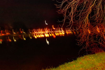 Close-up of illuminated lights against sky at night