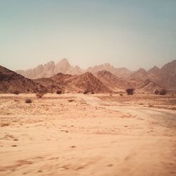Scenic view of desert and mountain against clear sky