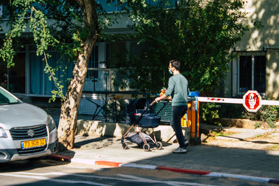 People on street against trees in city