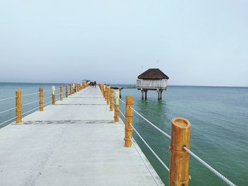 Pier on sea against clear sky