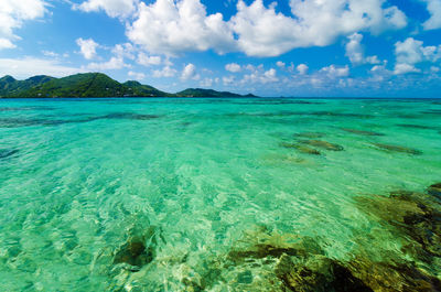 View of island in sea against cloudy sky