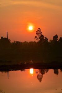 Scenic view of lake against orange sky during sunset