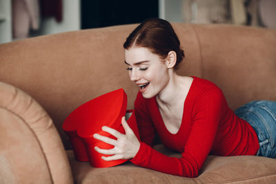 Young woman sitting on sofa at home