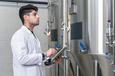 Brewer checking quality of beer at factory