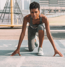 Portrait of woman preparing for race on road