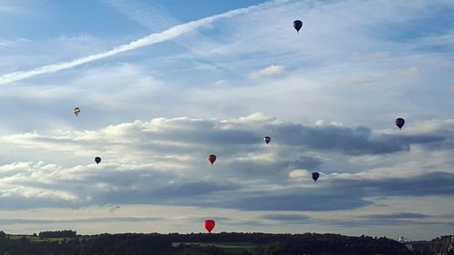 Hot air balloons flying over landscape