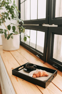 Delicious delicious breakfast a cup of coffee and an almond croissant on a tray in a cozy hotel