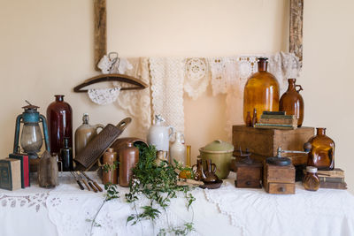 Empty chairs and table with glassware against wall at home