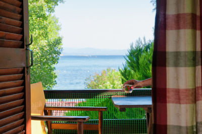 Cropped image of woman hand holding coffee cup in balcony