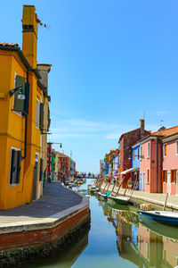 Boats in canal against blue sky