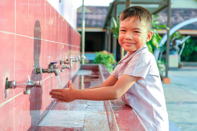 Boy washing hands in sink