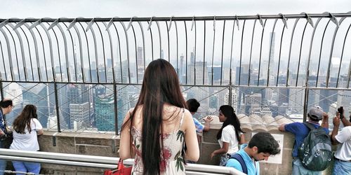 People standing by railing against built structure