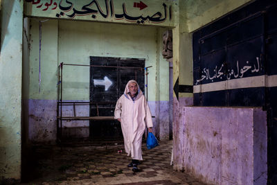 Full length of woman standing in abandoned building