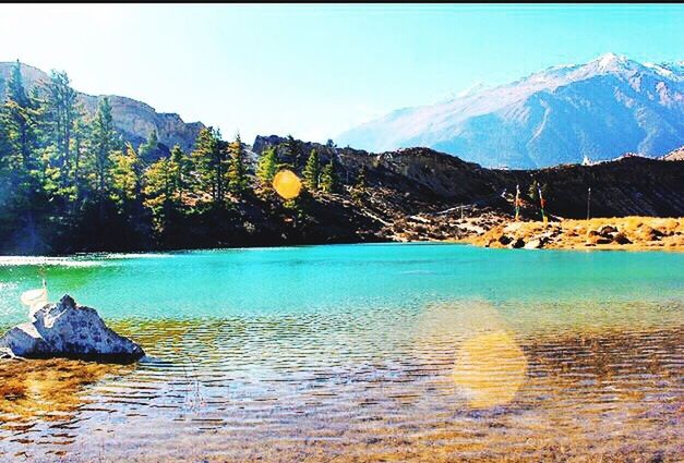 water, mountain, tranquil scene, tranquility, scenics, lake, beauty in nature, clear sky, mountain range, reflection, nature, rock - object, blue, waterfront, idyllic, non-urban scene, rock formation, sky, river, remote