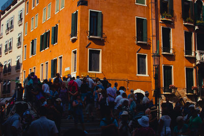 People on street against buildings in city