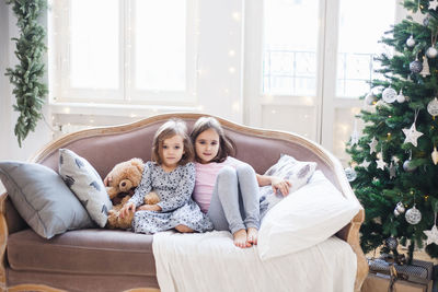 Portrait of smiling girl sitting on sofa