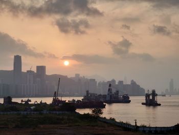 Scenic view of sea and buildings against sky during sunset