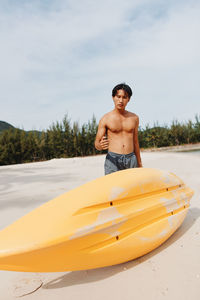 Portrait of shirtless man kayaking in sea