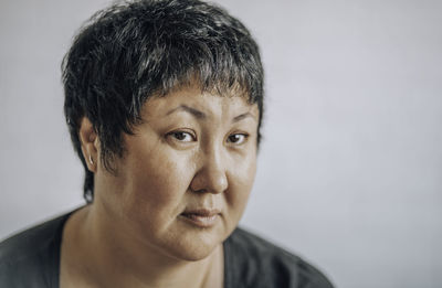 Asian woman of forty with a short haircut on a white background