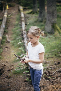 Girl holding sticks in forest