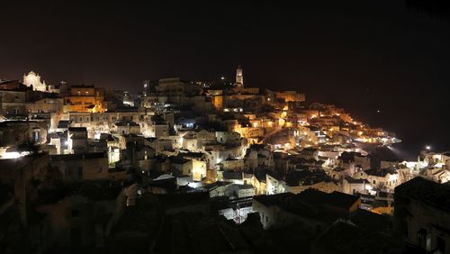 Illuminated cityscape against sky at night