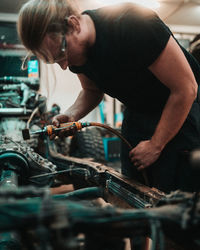 Side view of man working on a car