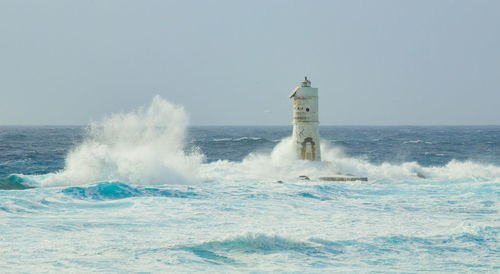 Stormy cloudy day. dramatic sky and huge waves at the mangiabarche lighthouse, calasetta, italy