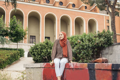 Portrait of a muslim woman siting on a wall