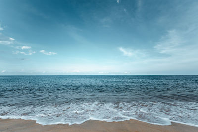 Beautiful sea waves with foam of turquoise color horizon with blue sky and beautiful sand