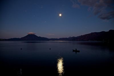 Scenic view of lake against sky at night