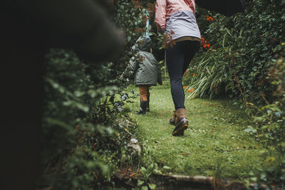 Mother and son walking in the garden on a rainy day