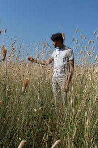 Man standing by plants against sky