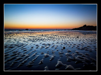 Scenic view of sea against clear sky at sunset