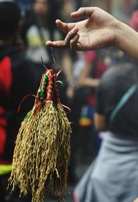 Cropped hand of street vendor selling wheat decoration at market