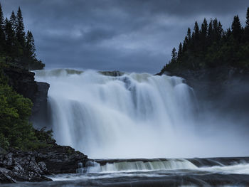 Idyllic tannforsen waterfall flowing against cloudy sky