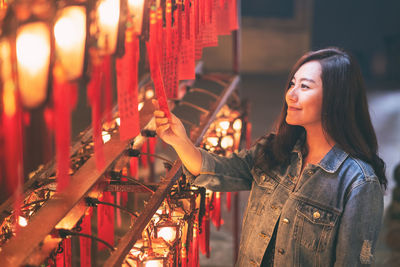 Smiling woman holding labels in temple