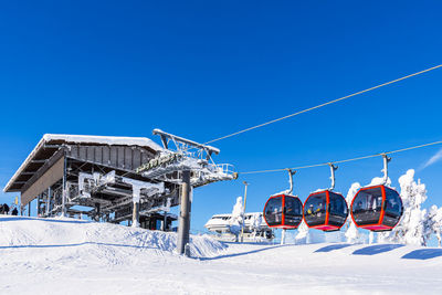 Low angle view of snow covered landscape against clear blue sky