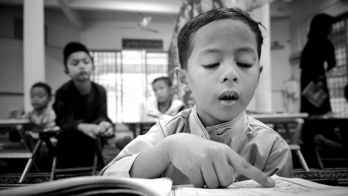 Boy reading book in classroom