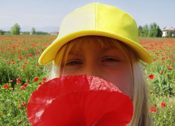Close-up portrait of young woman with red flowers