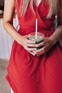 Midsection of woman holding red wine