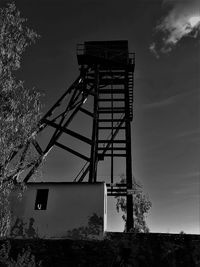 Low angle view of old tower on field against sky