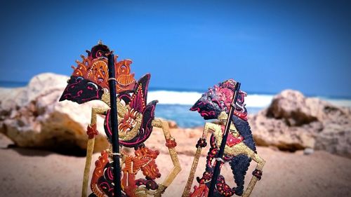 Close-up of multi colored umbrellas on beach against clear blue sky