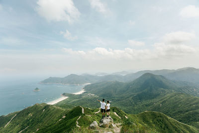 Rear view of people on mountain against sky