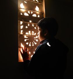 Boy looking at illuminated lamp at home