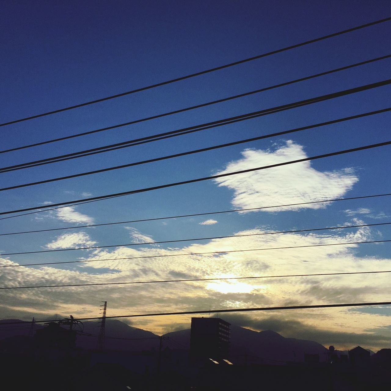 power line, electricity pylon, sky, electricity, cable, power supply, low angle view, blue, cloud - sky, connection, power cable, silhouette, cloud, built structure, nature, fuel and power generation, outdoors, technology, building exterior, no people