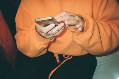 Close-up of man photographing woman with mobile phone