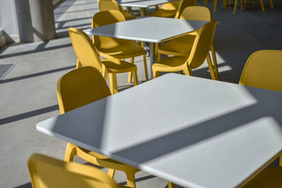 High angle view of empty chairs and table at cafe