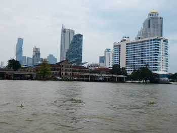 River by buildings against sky in city