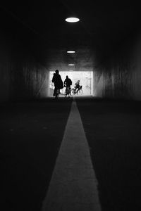Silhouette people walking in tunnel