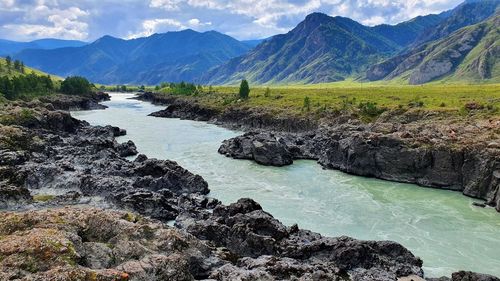 Scenic view of river amidst mountains against sky